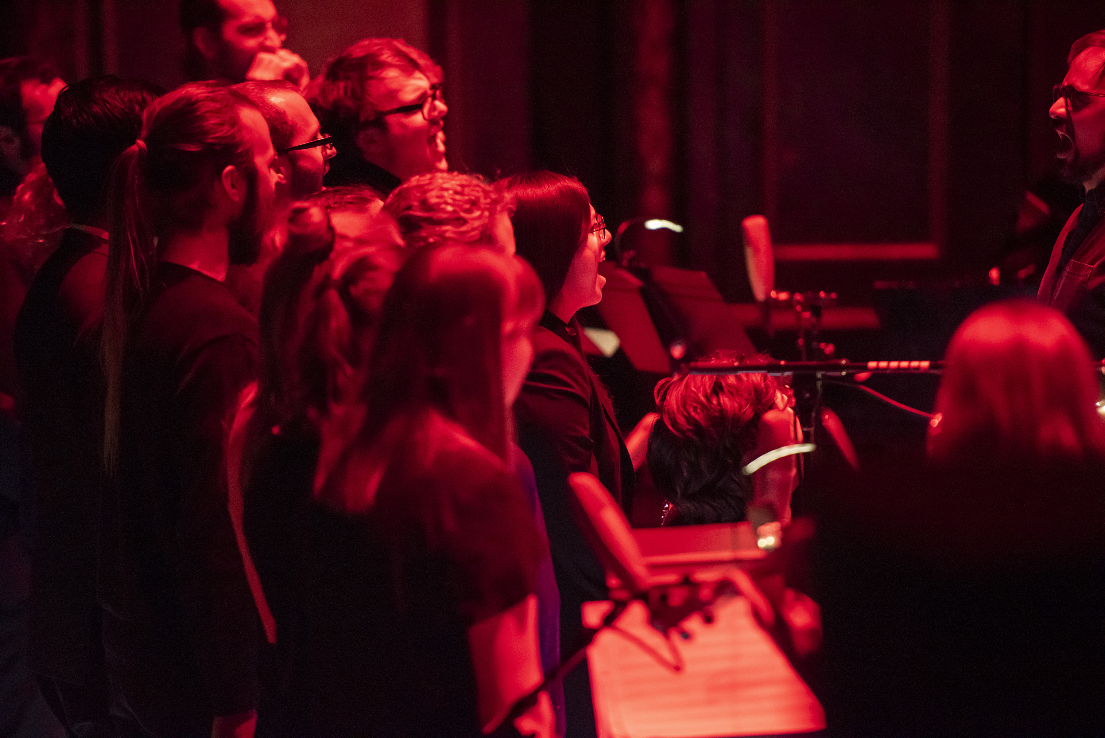 Red lights on students performing on Jordan Hall stage