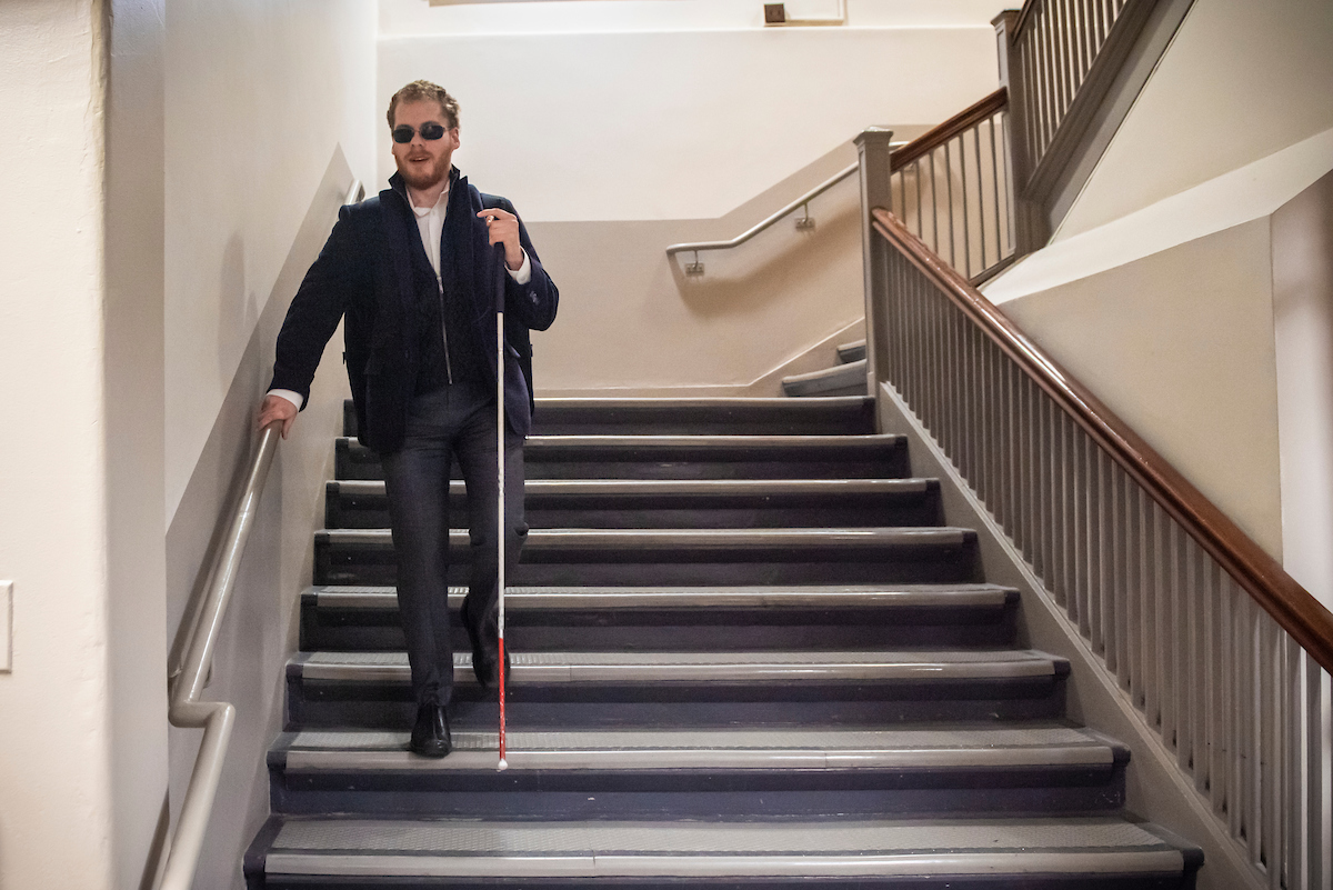 Student Matthew Shifrin descending stairs with his cane