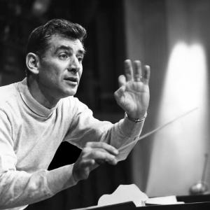 Leonard Bernstein conducting, holding a baton in his right hand.