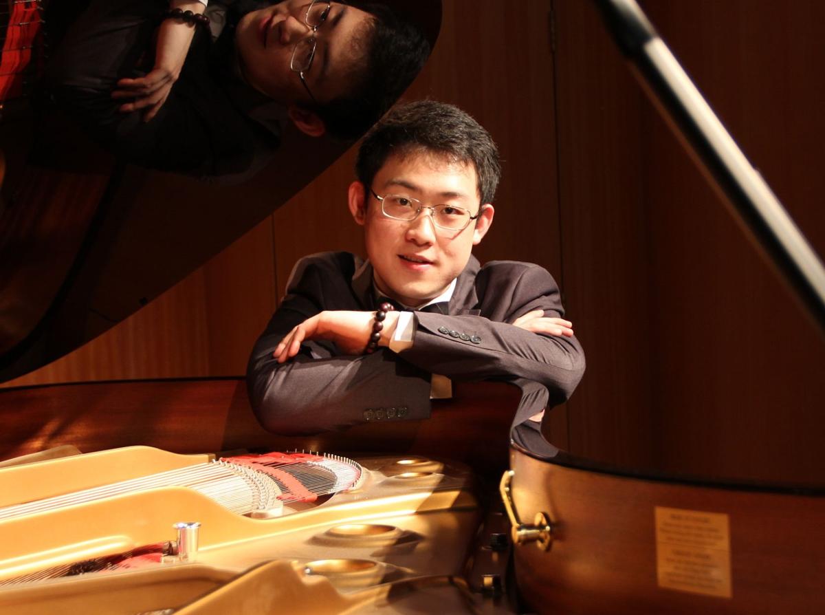 Ziang Xu leaning on piano