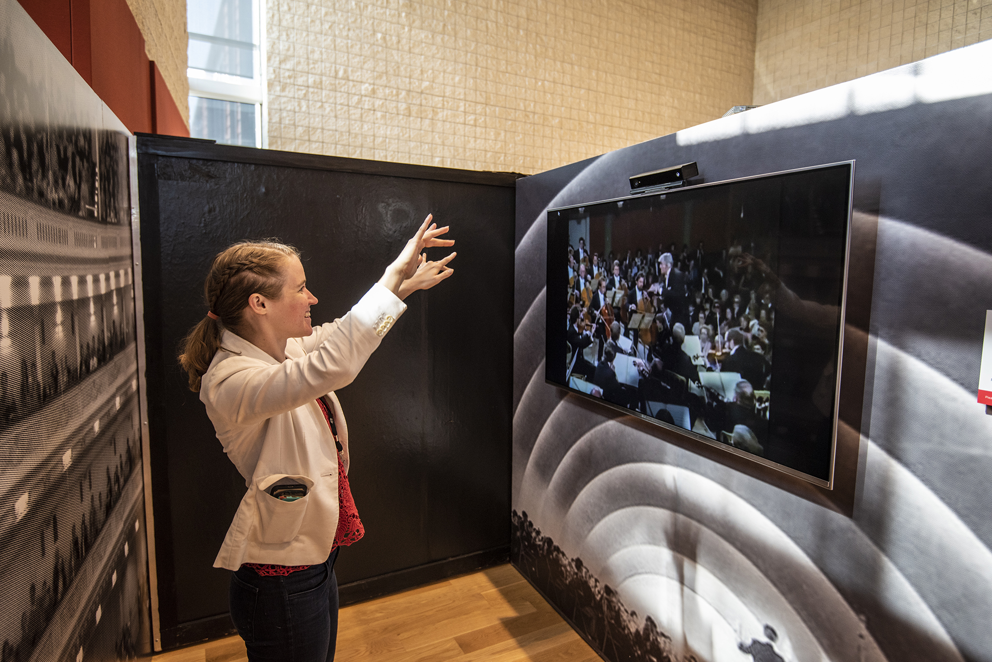 A visitor tries the interactive conducting experience at the Leonard Bernstein at 100 exhibit, on display in NEC's Burnes Hall.