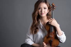 YooJin Jang holds her violin and looks at the camera