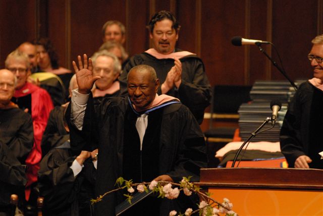 Freddy Cole waves and smiles while receiving an honorary doctorate from NEC.