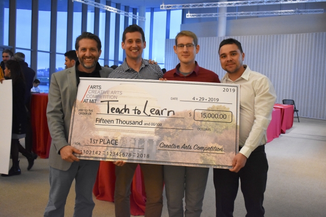 Four people hold up a giant check made out to Teach to Learn
