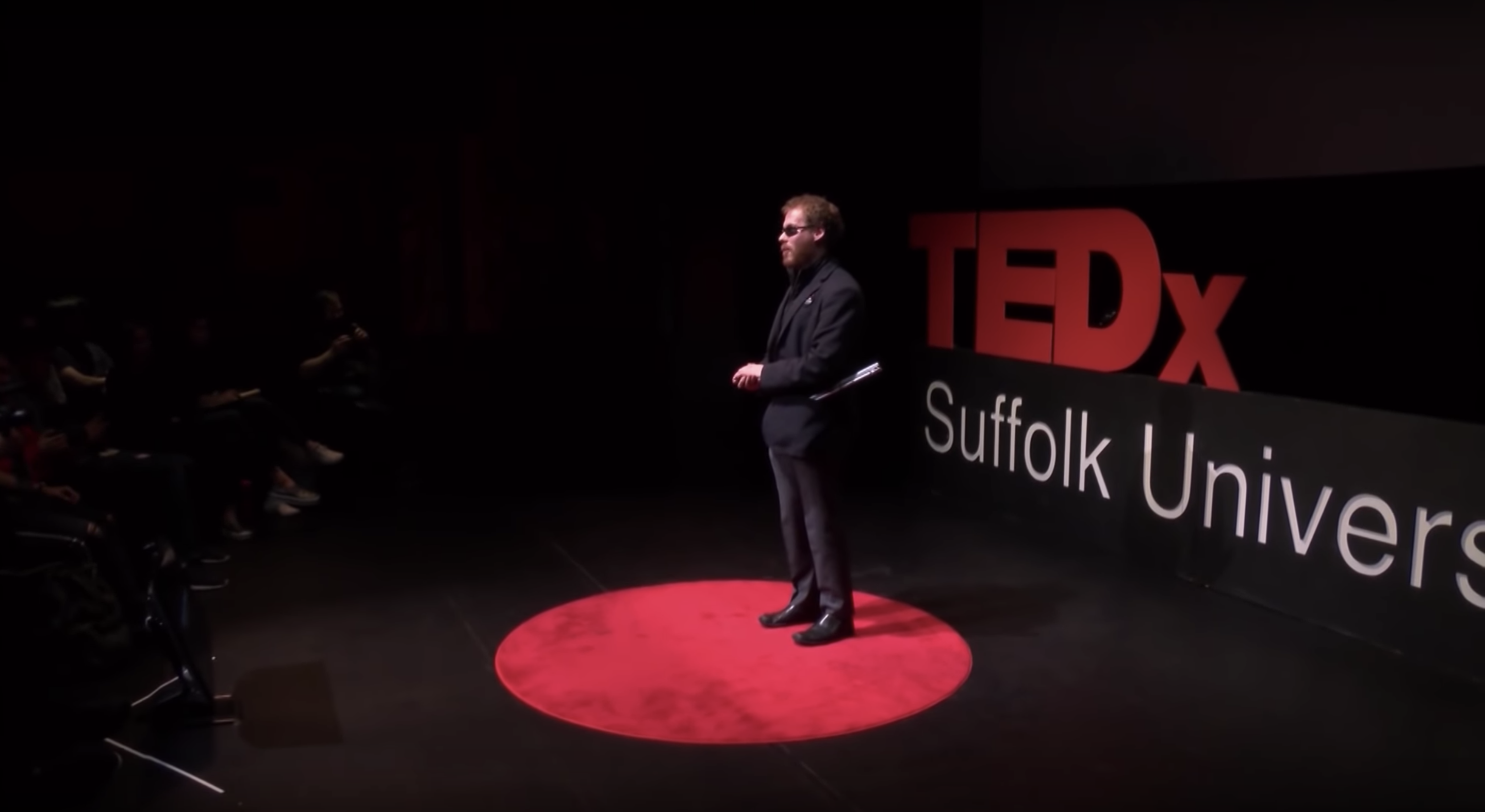 Matthew Shifrin giving a talk on Tedx stage Suffolk University