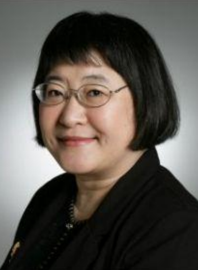 Chen Yi headshot. Ms. Chen smiles at the camera. She is wearing glasses and has short dark hair. The background is grey.
