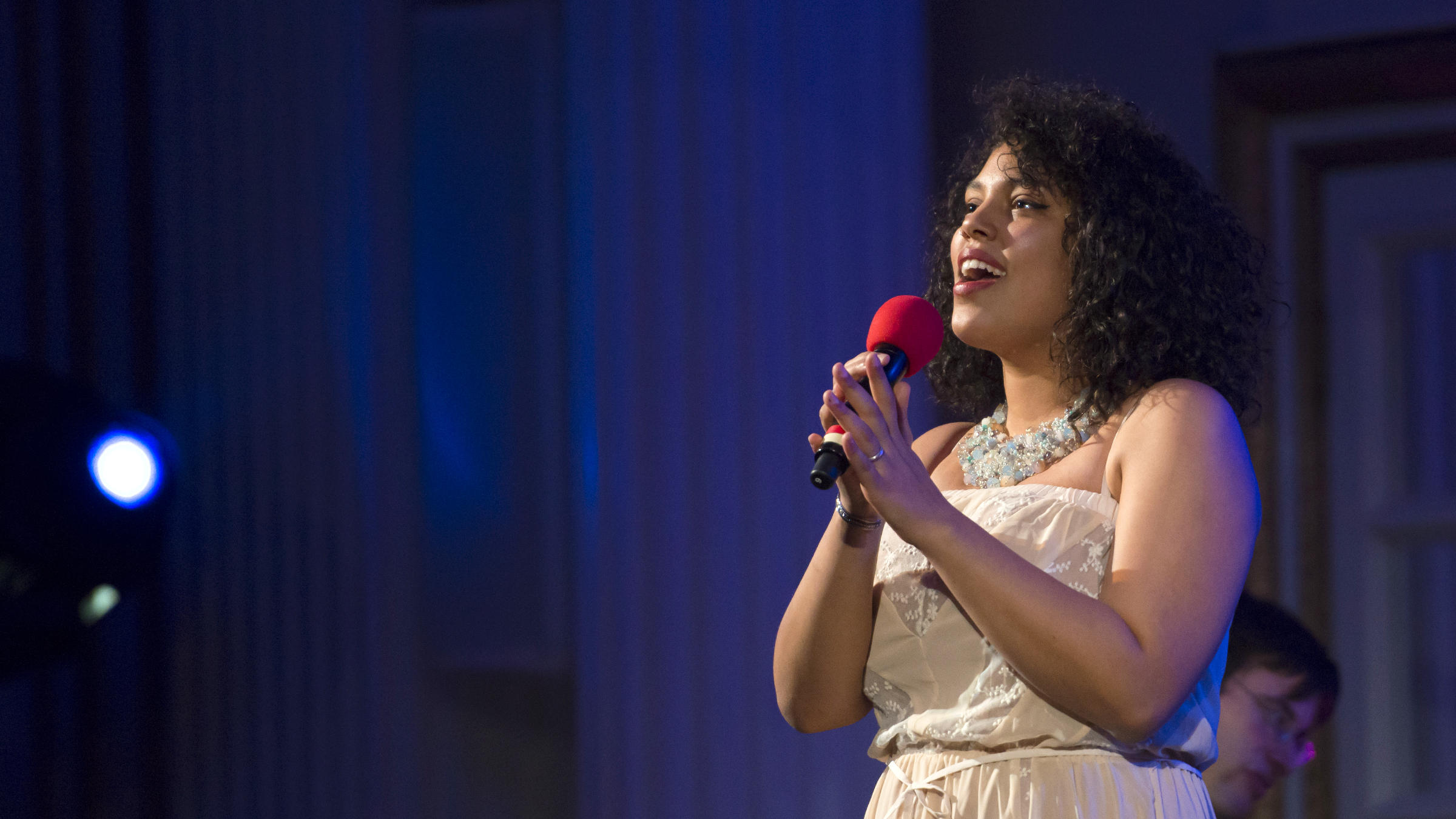A female jazz singer sings into a microphone.