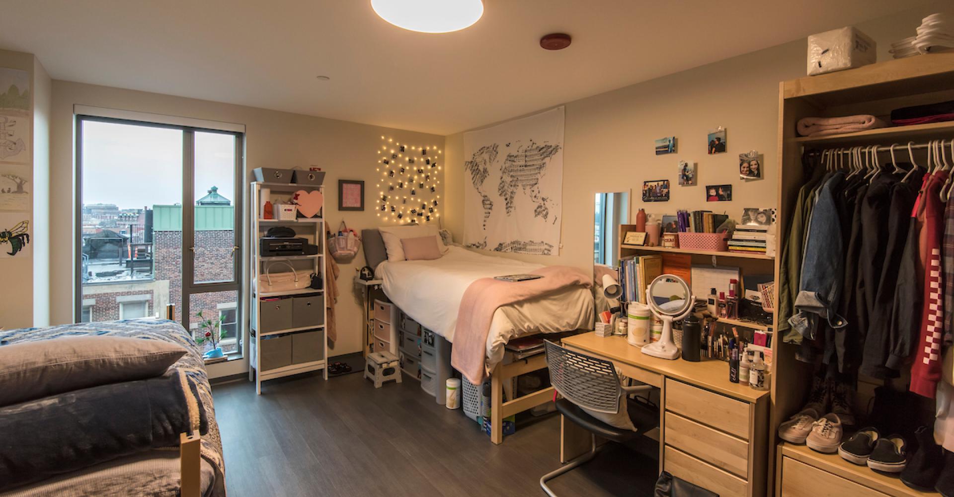 A dorm room decorated in the Student Life and Performance Center, with a Boston skyline view visible through the window.