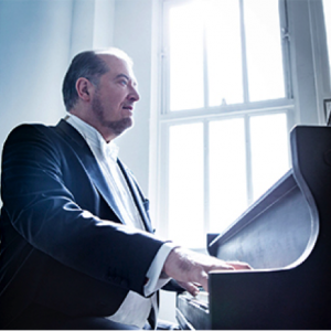 Pianist Garrick Ohlsson sits at a piano