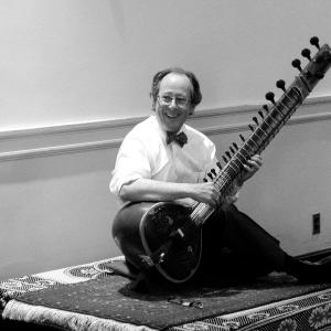 Peter Row holding a sitar