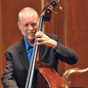 Dave Holland smiles while playing bass during a performance