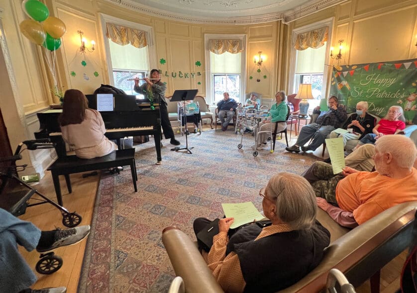 Students performing a St. Patrick's Day concert in an assistant living facility.