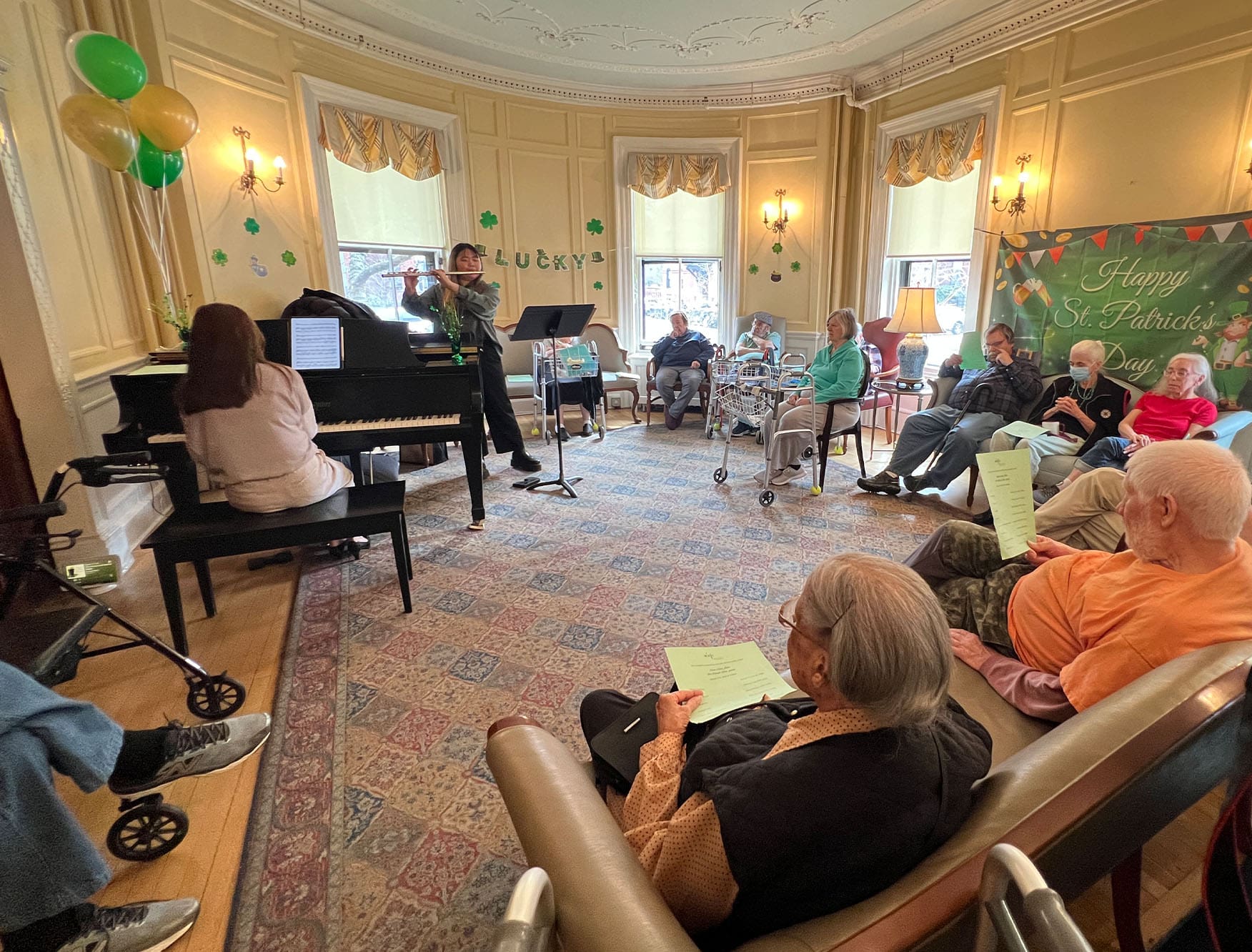 Students performing a St. Patrick's Day concert in an assistant living facility.
