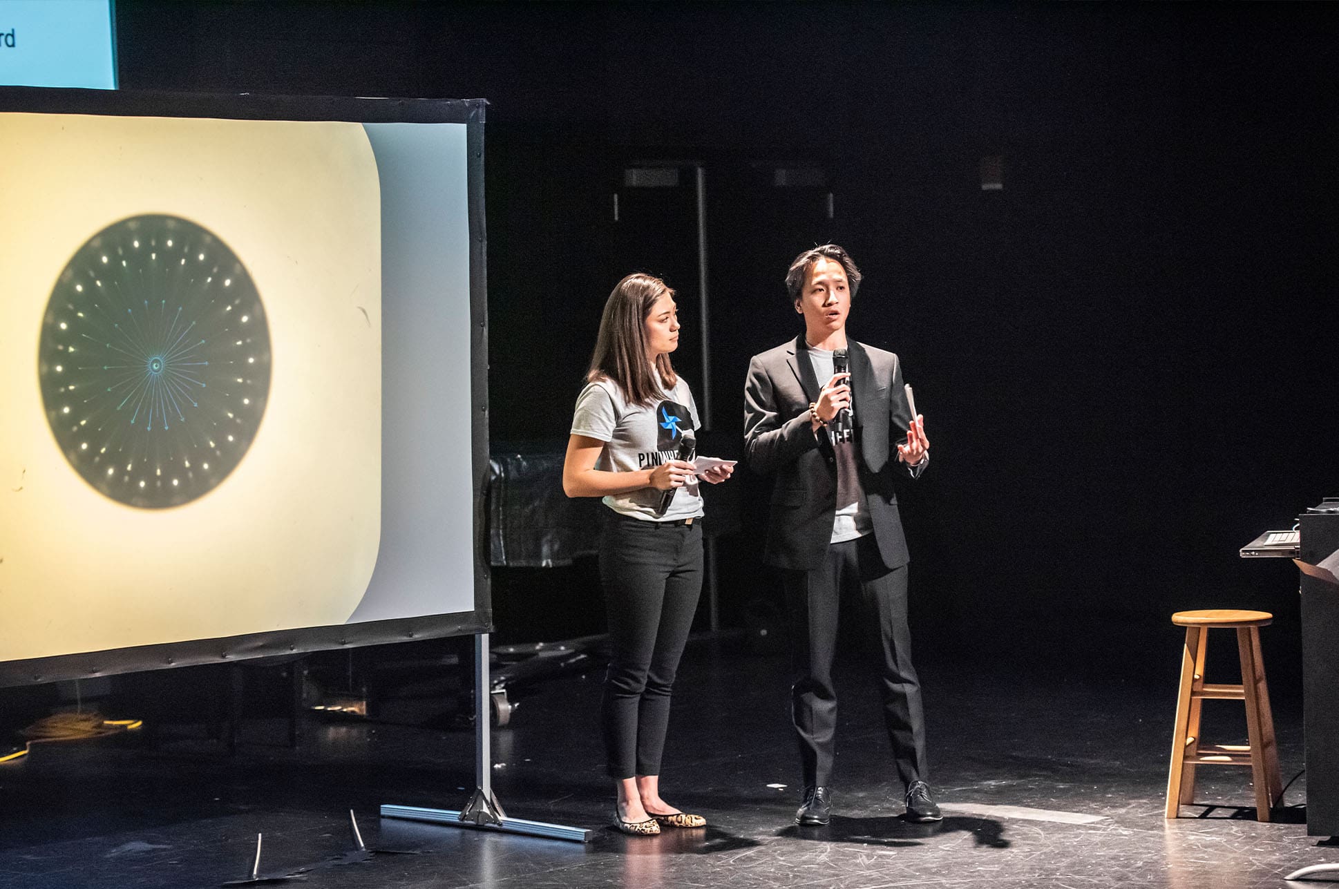 Two people making a presentation on stage.