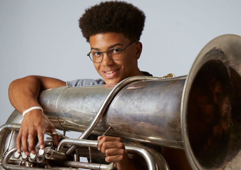 A student holding a tuba.