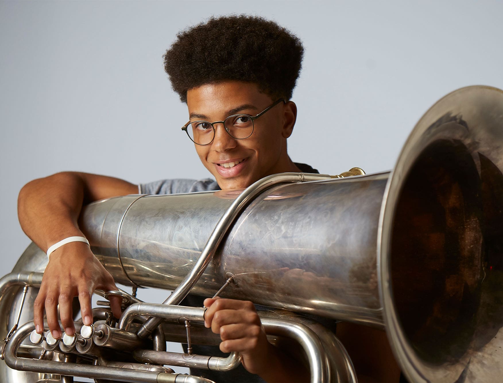 A student holding a tuba.