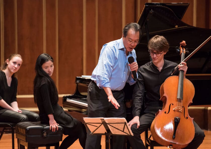 A teacher instructing three students with their instruments on the Jordan Hall stage.