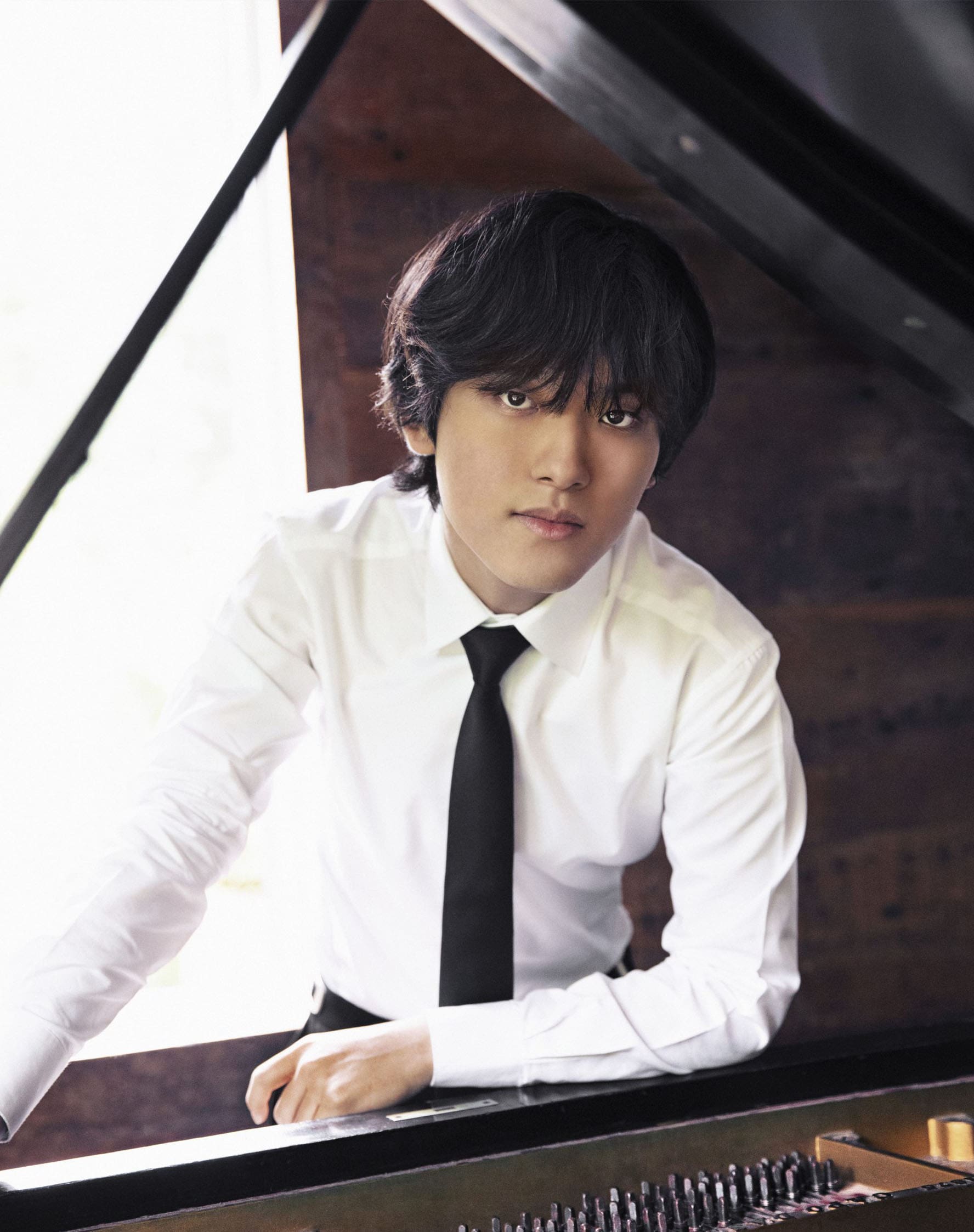 Yunchan Lim leaning on a piano.