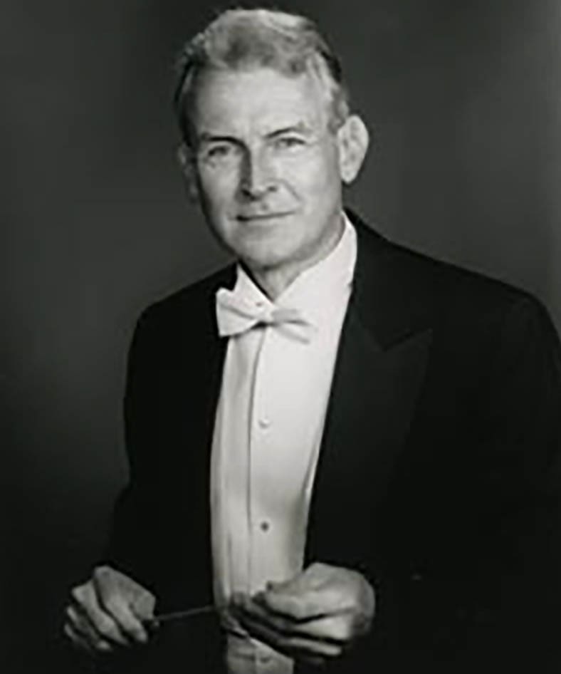 Portrait image of former NEC faculty member, F. John Adams, holding his conducting baton.
