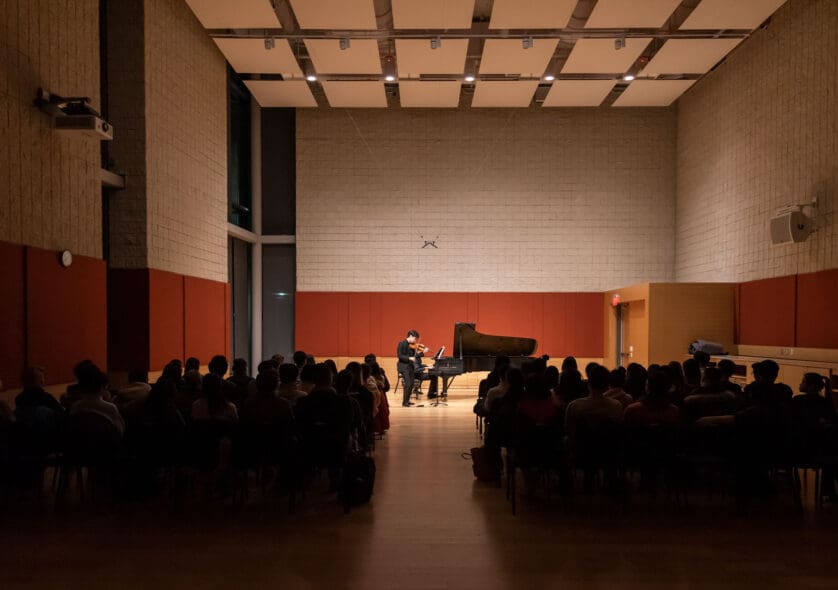 Person performing on a piano in Burnes Hall.