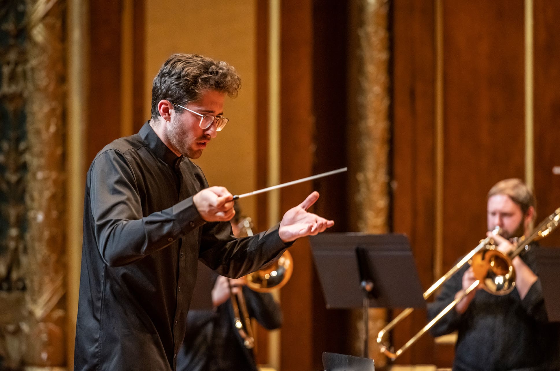 A student conductor leads musicians on the Jordan Hall stage