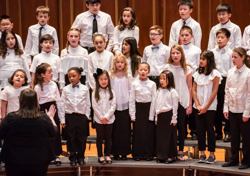Young students singing in a choral ensemble.