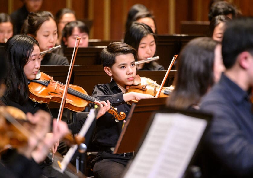 Young students playing in an orchestra.
