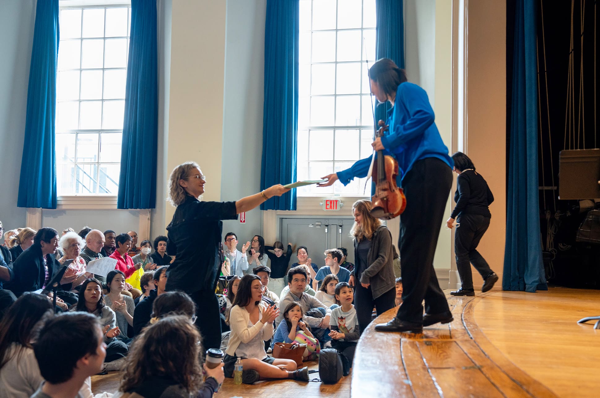 Hilary Hahn reaching out to a student on stage in Williams Hall during her master class.