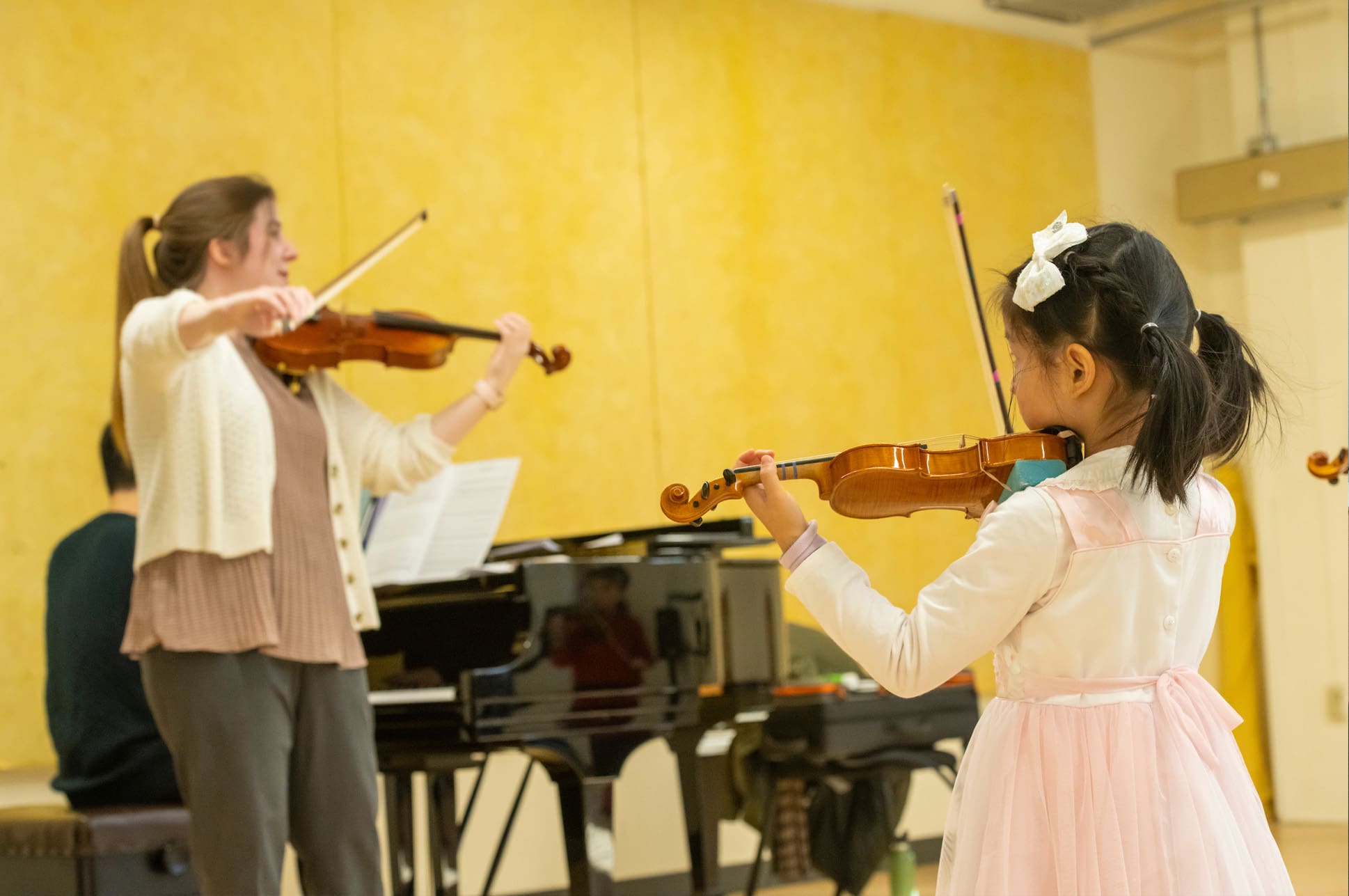 Young violinist playing with teacher