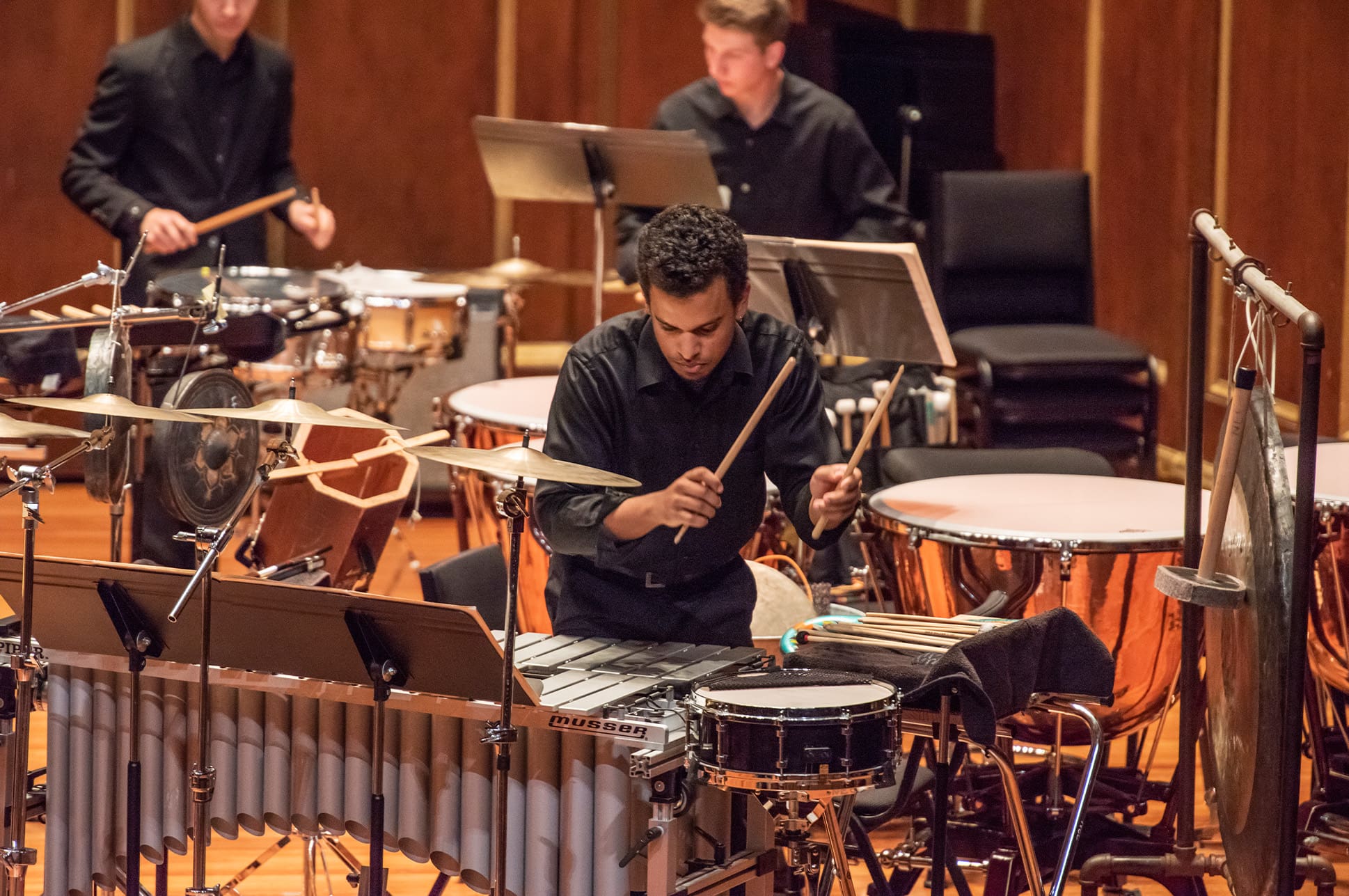Percussionist performing with ensemble on stage