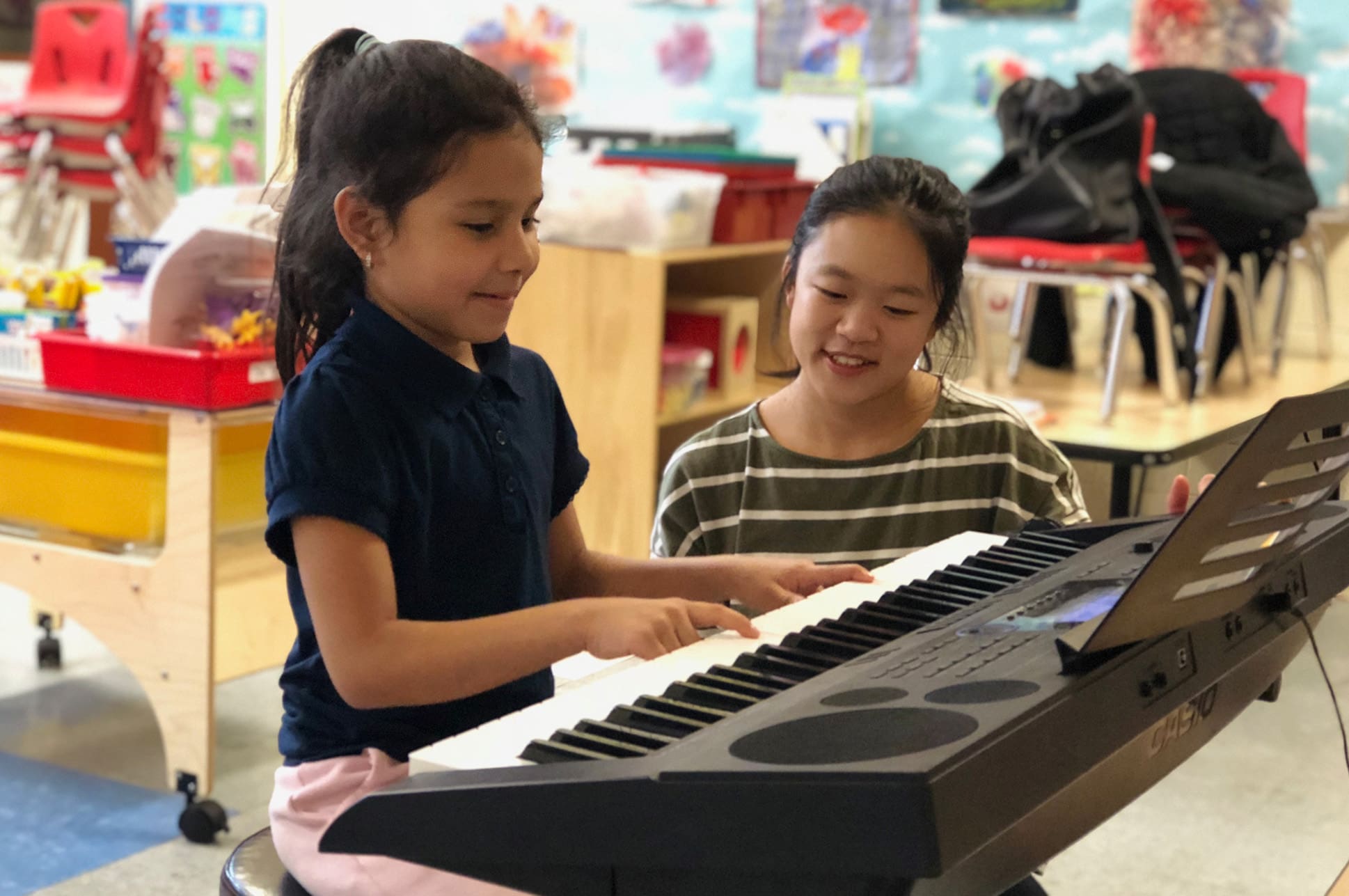 An NEC student teaches a child piano