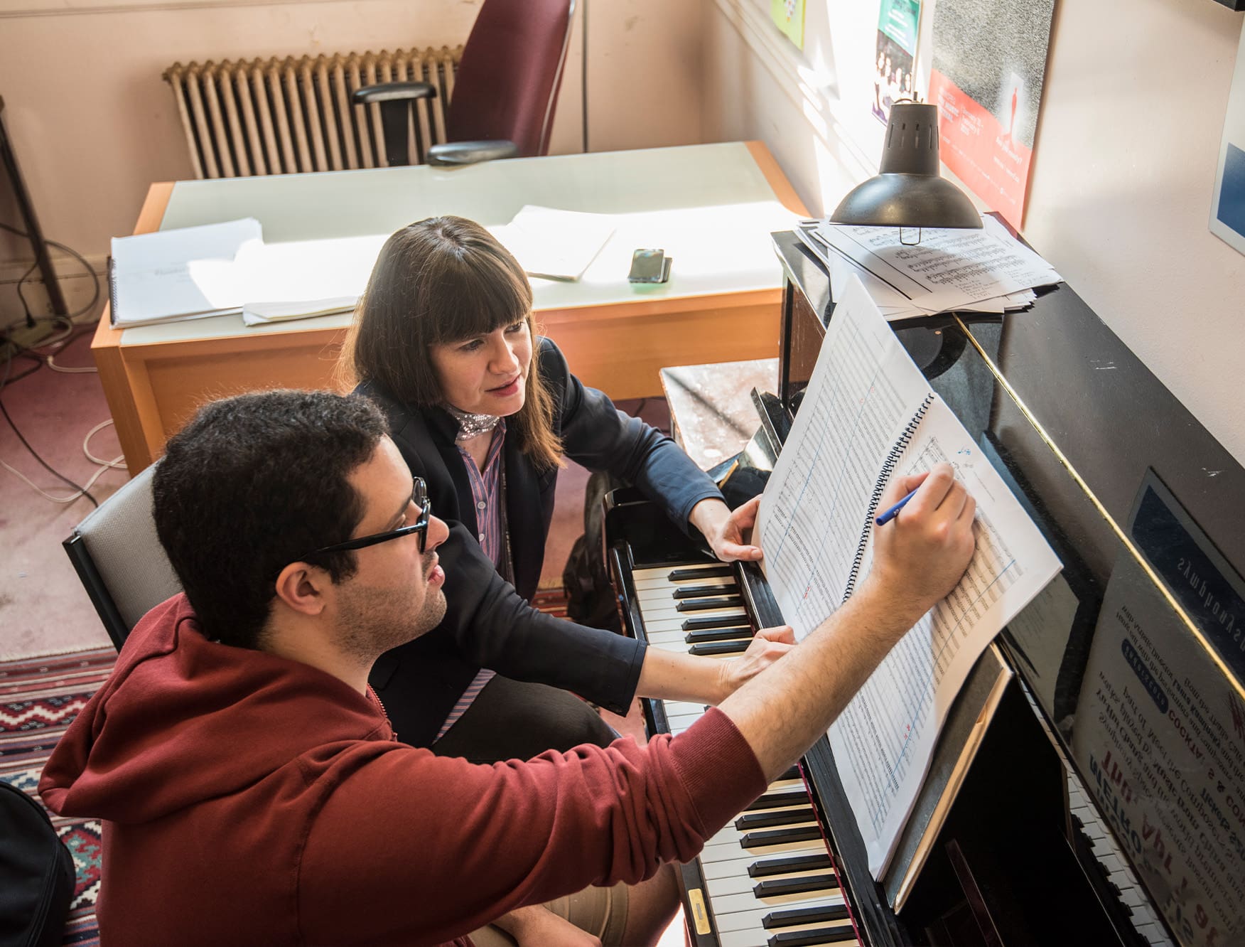 evaluating sheet music at a piano