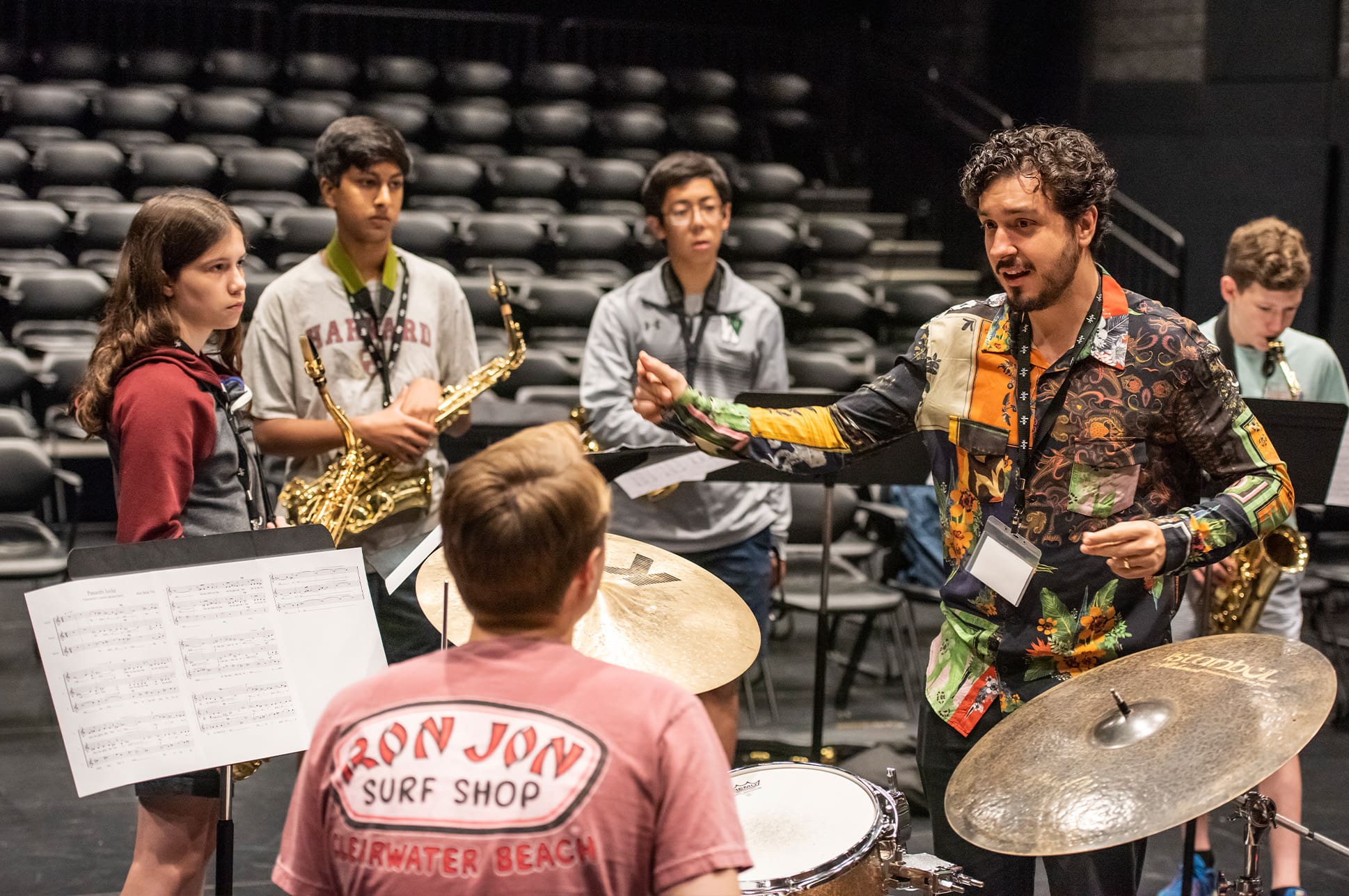 Music teacher and a group of students talking together.