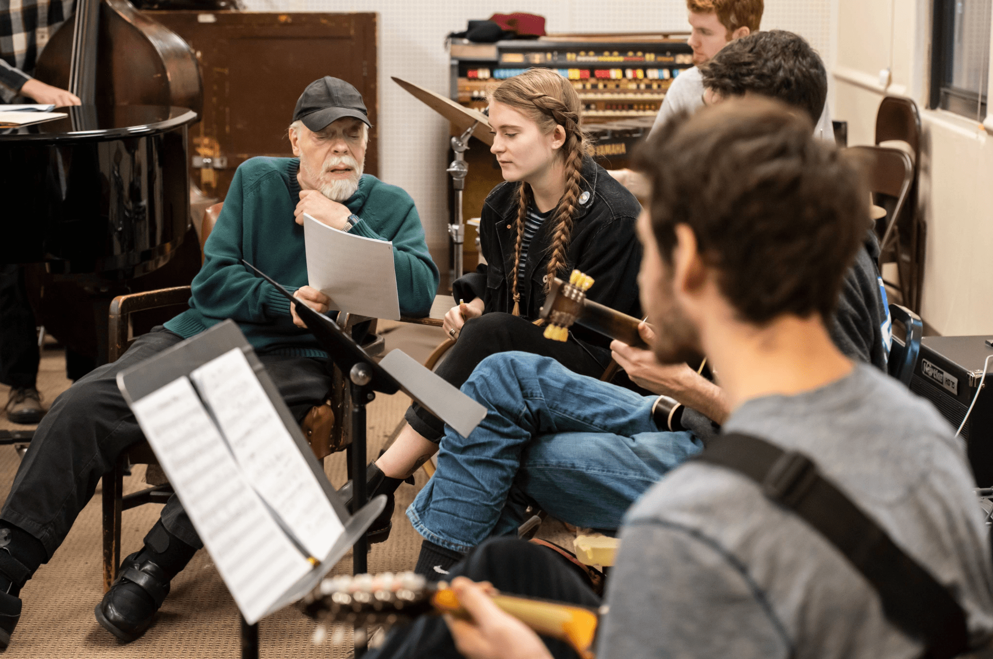 John McNeil sitting with students in an classroom.