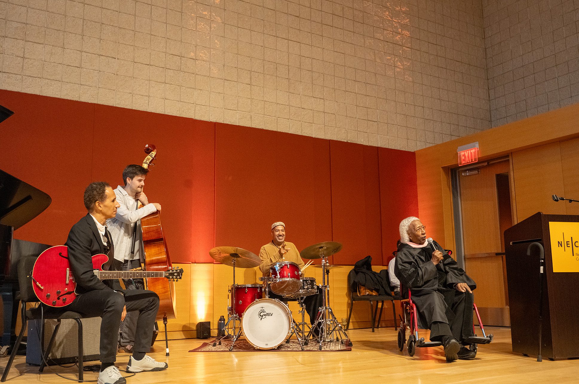 Marvin E. Gilmore, Jr. speaking in front of a jazz band.