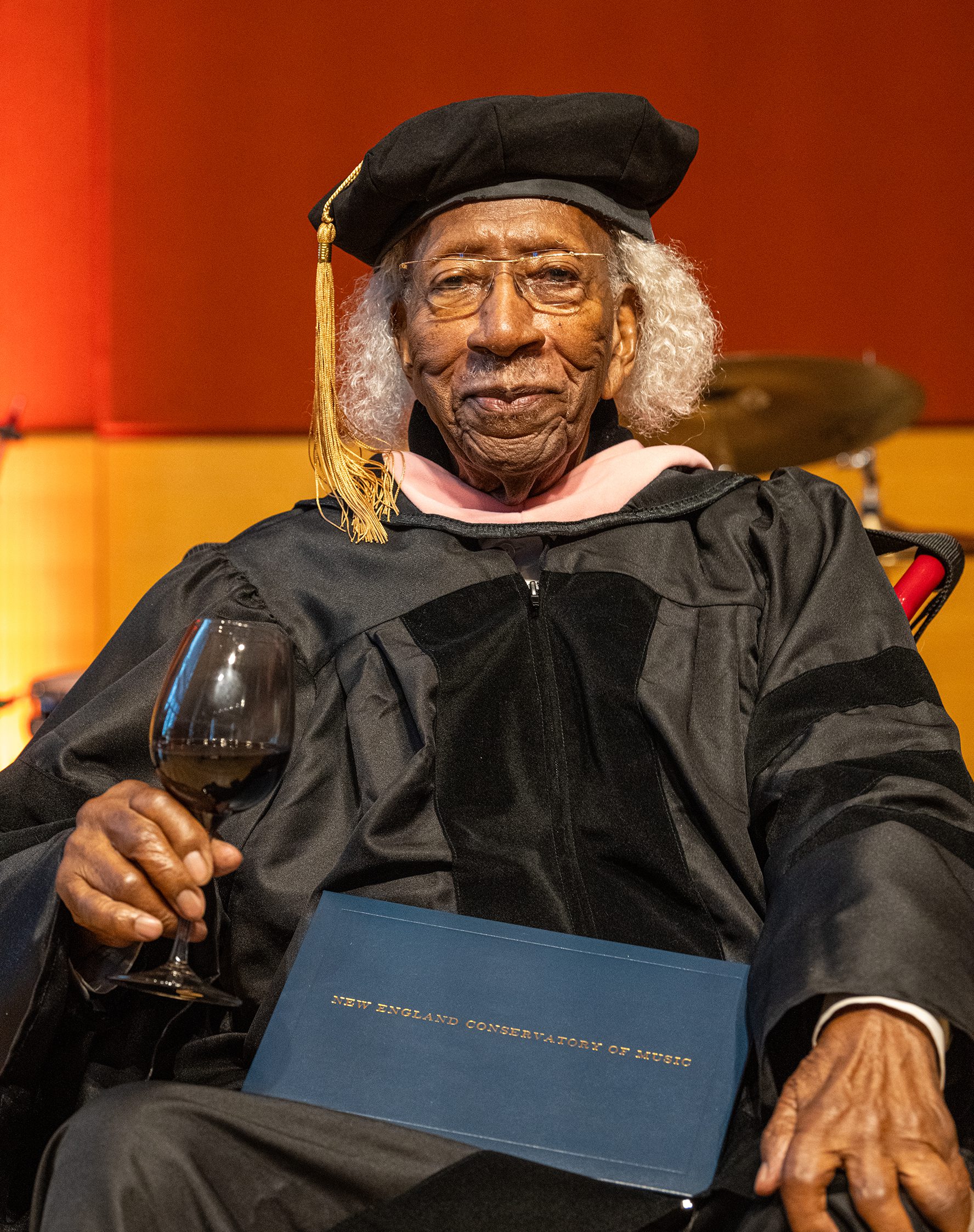 Marvin E. Gilmore, Jr. smiling and holding his honorary doctorate.