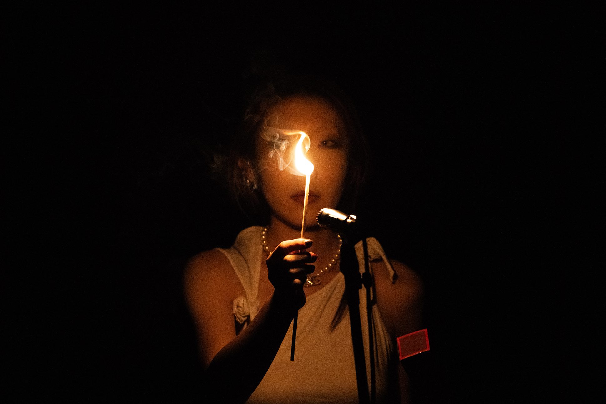 Elfie Shi ’25 lighting a match as part of Raven Chacon's narrative score, "American Ledger No. 1."