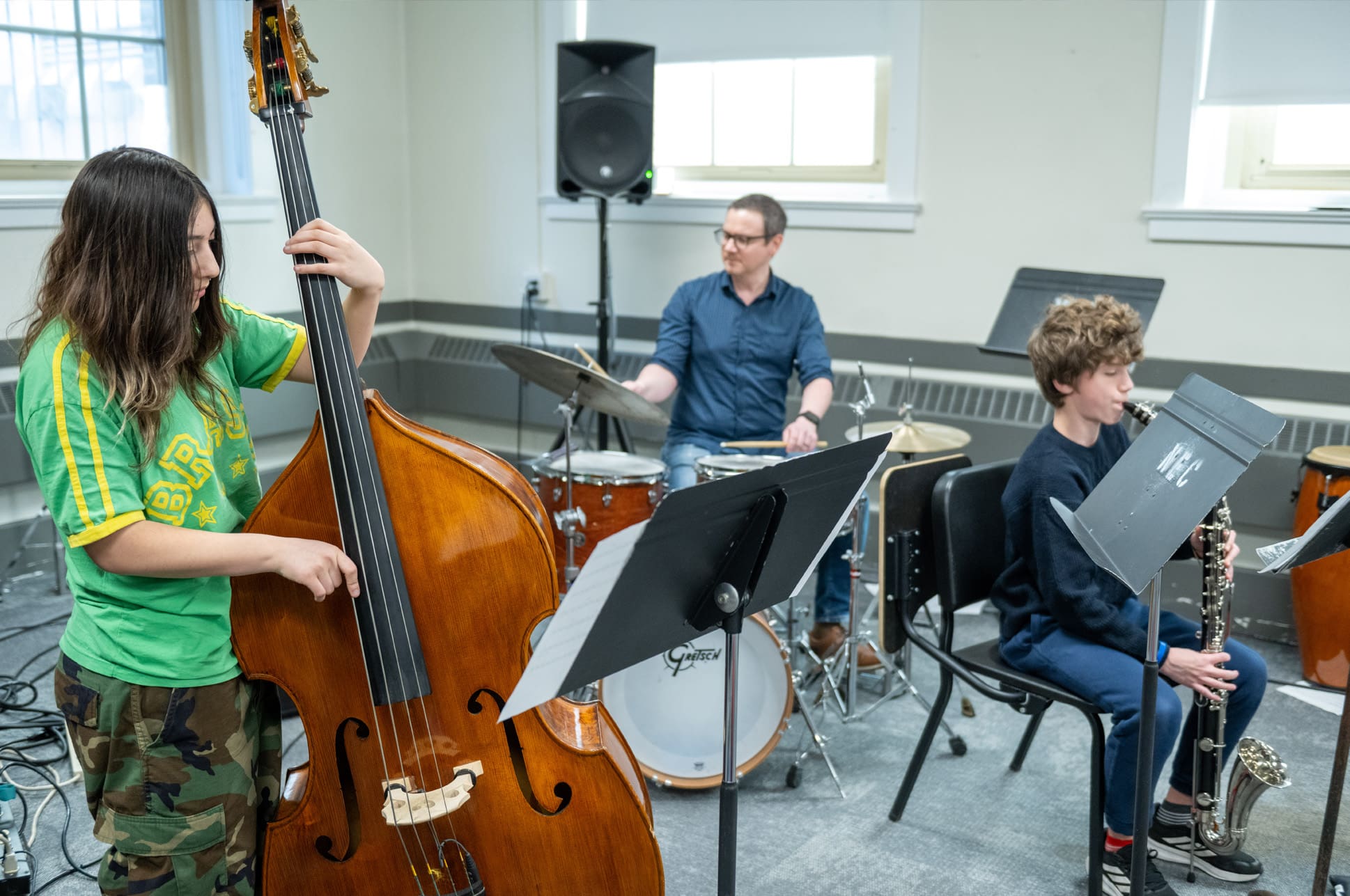 Prep-Info Session-Jazz Ensemble Jazz trio featuring two young students on double bass and saxophone and an adult teacher on drums.
