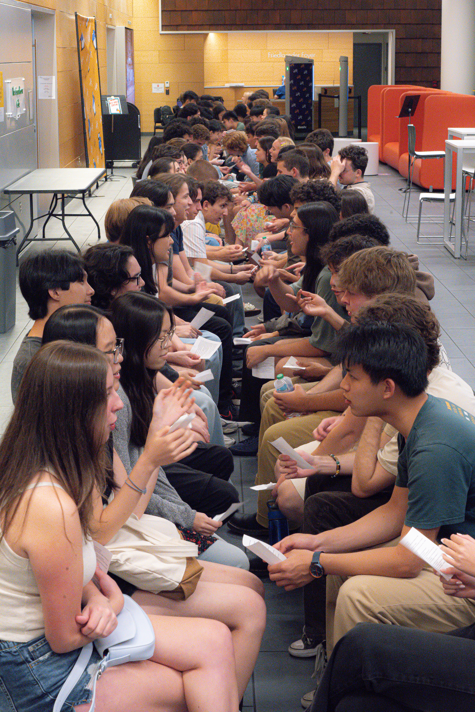 Students sitting in a line participating in an orientation activity.