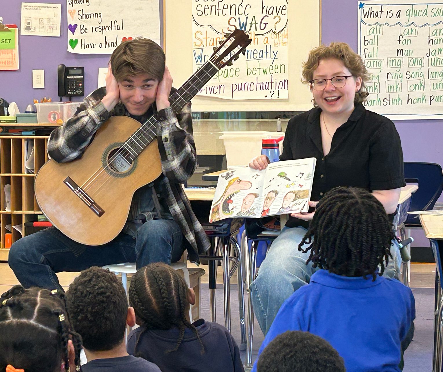 Two musicians teaching a class of young children in a classroom. Two musicians teaching a class of young children in a classroom.