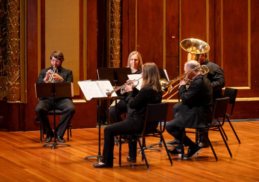 Trumpeters Ryan Noe and Elizabeth Jewell, horn player Lauren Winter, trombonist Brian Diehl, and tubist Eric Goode perform in Jordan Hall.