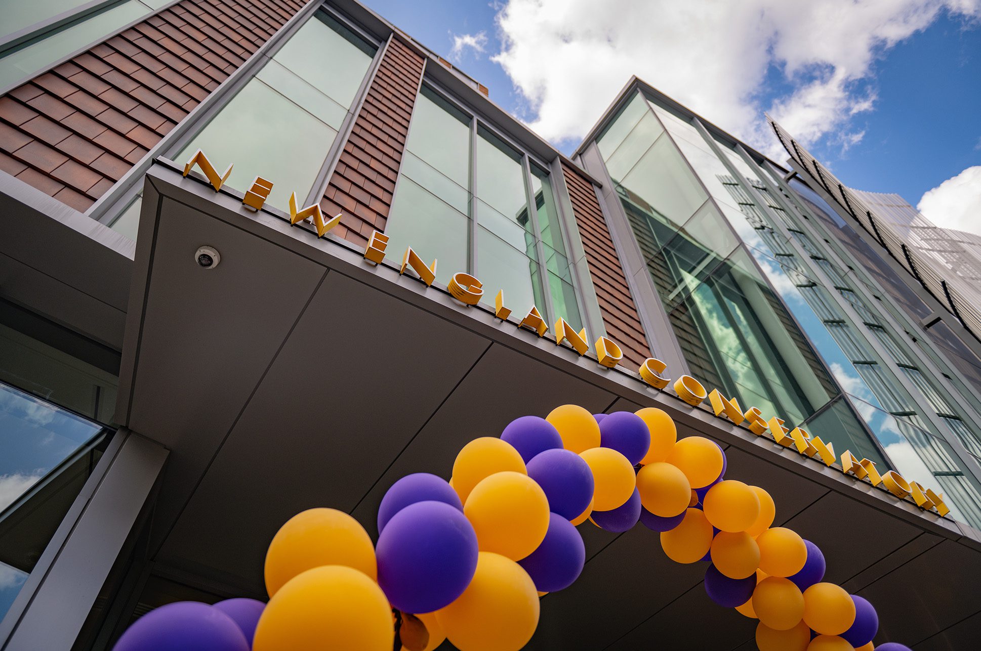 Exterior photo of NEC's SLPC building entrance with a balloon arch. Exterior photo of NEC's SLPC building entrance with a balloon arch.