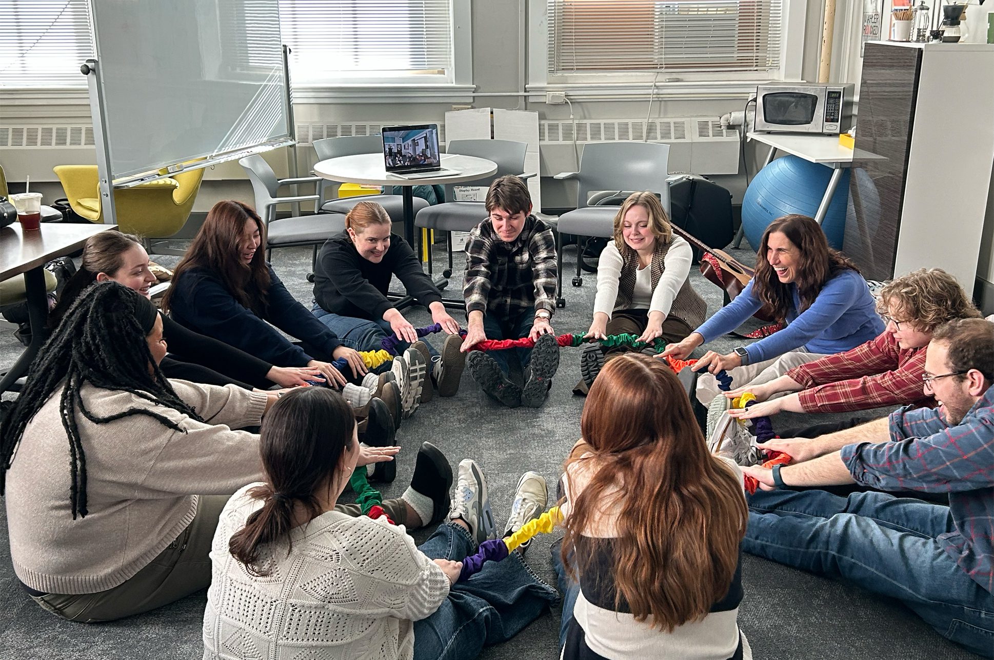 A group of people sitting in a circle participating in a music education workshop.