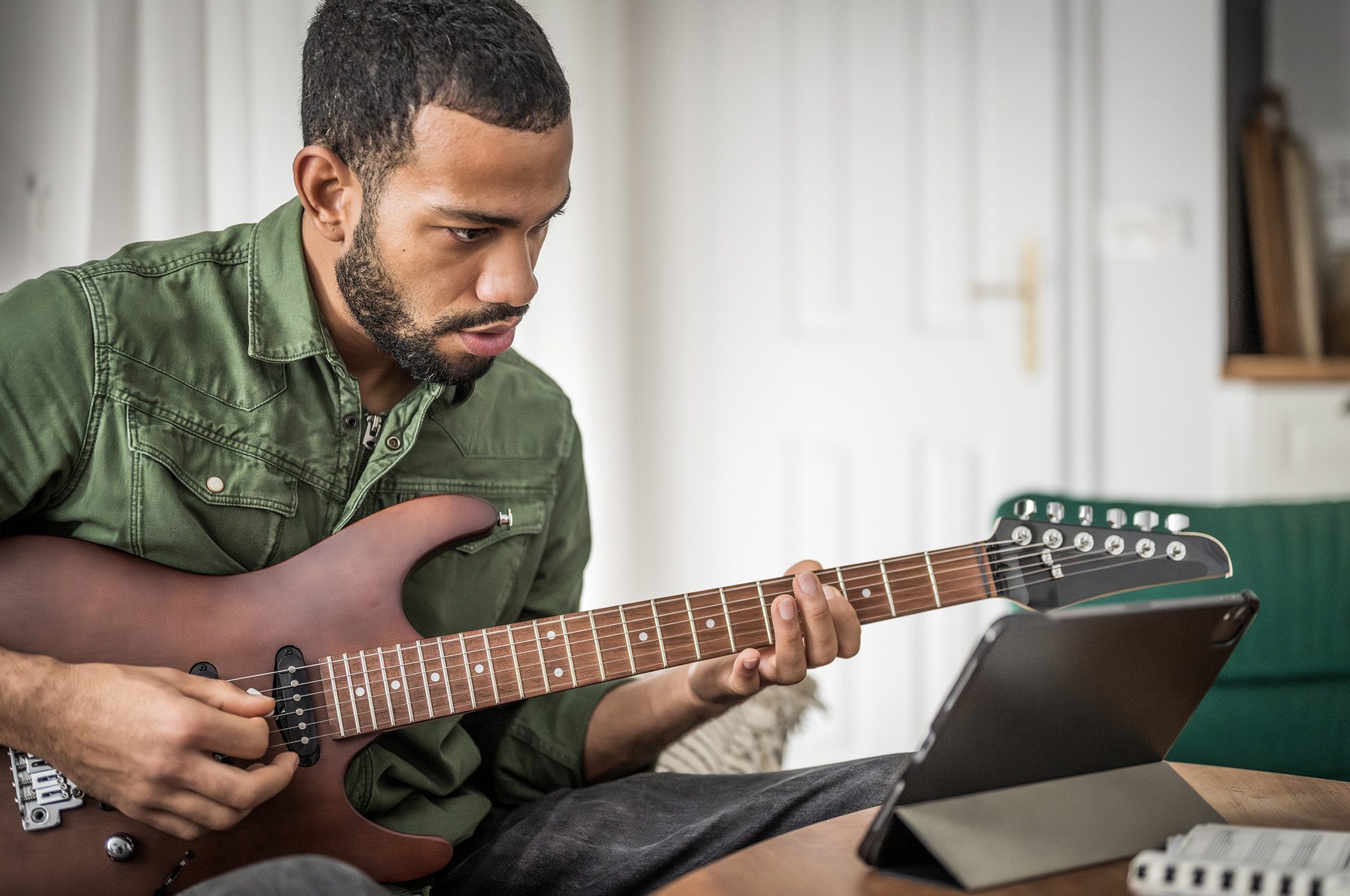 Person taking an online guitar lesson.