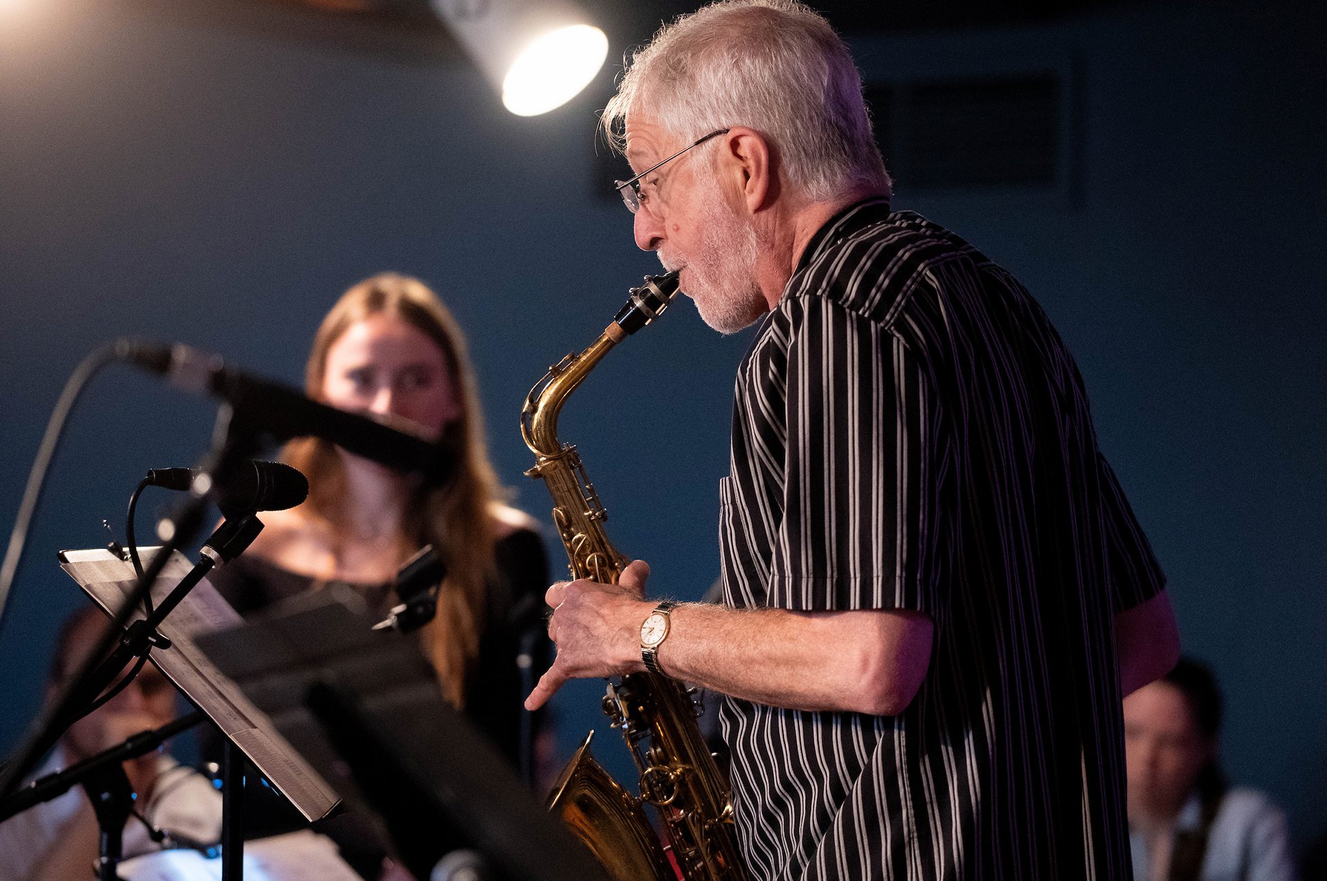 Person playing a saxophone at a recital.