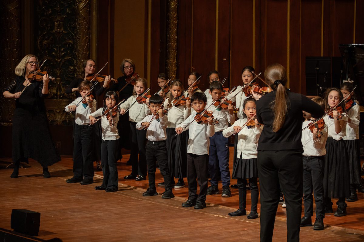 A Suzuki ensemble performs Lesa Longay's "Snowflakes, Wind, Mist, Moon."