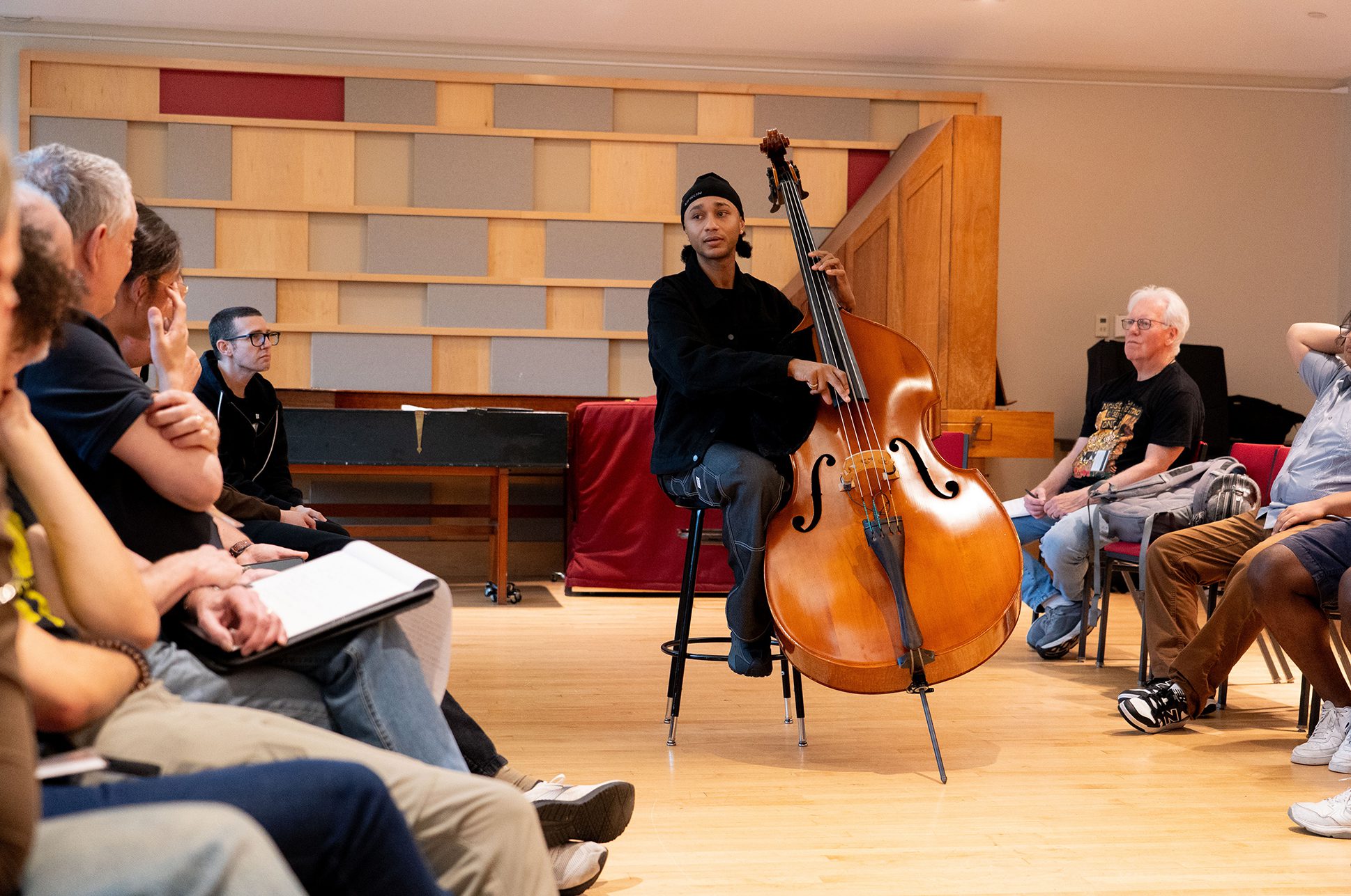Jazz bassist teaching a class holding his instrument.