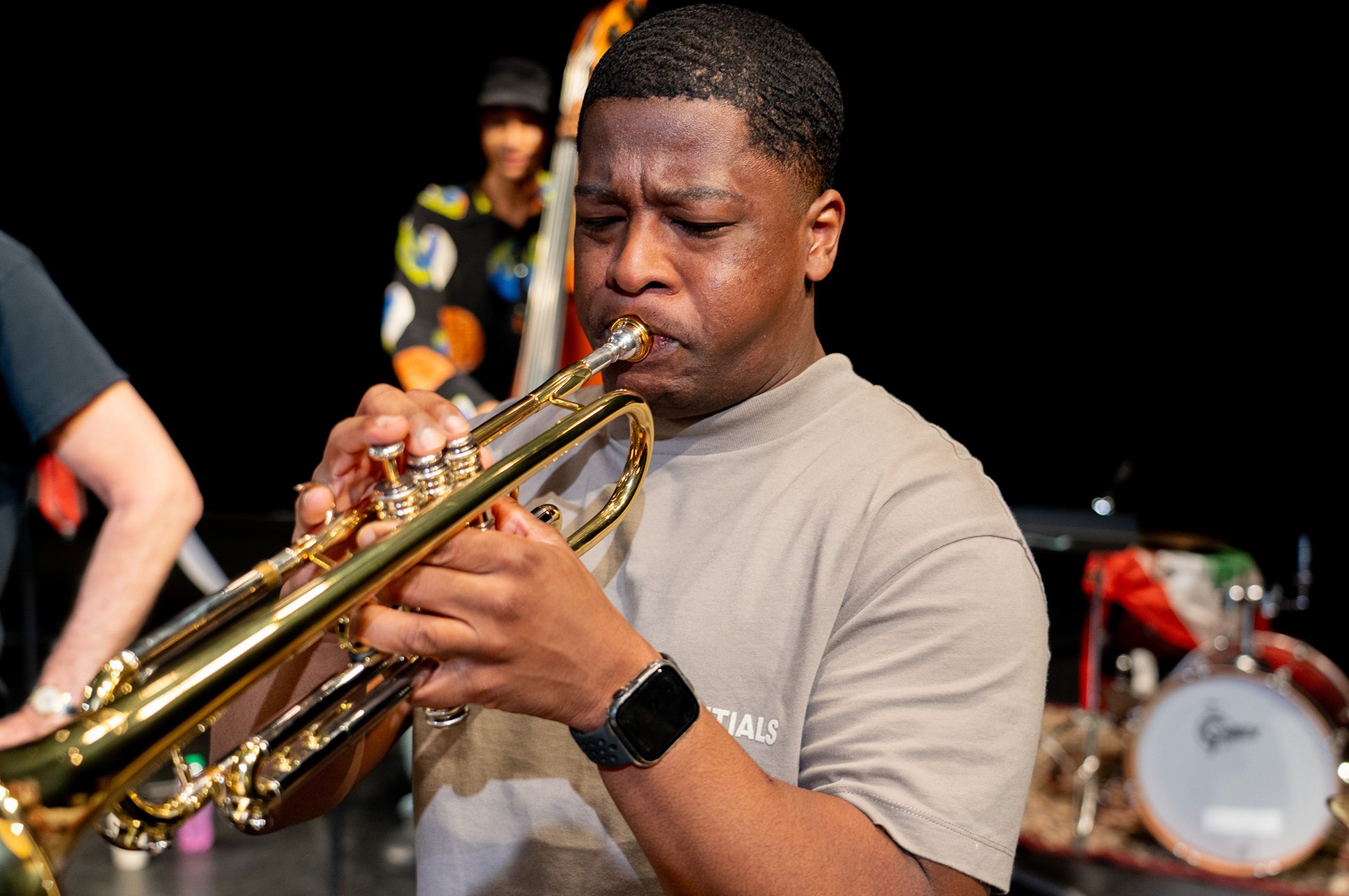 Person playing the trumpet in a jazz ensemble.