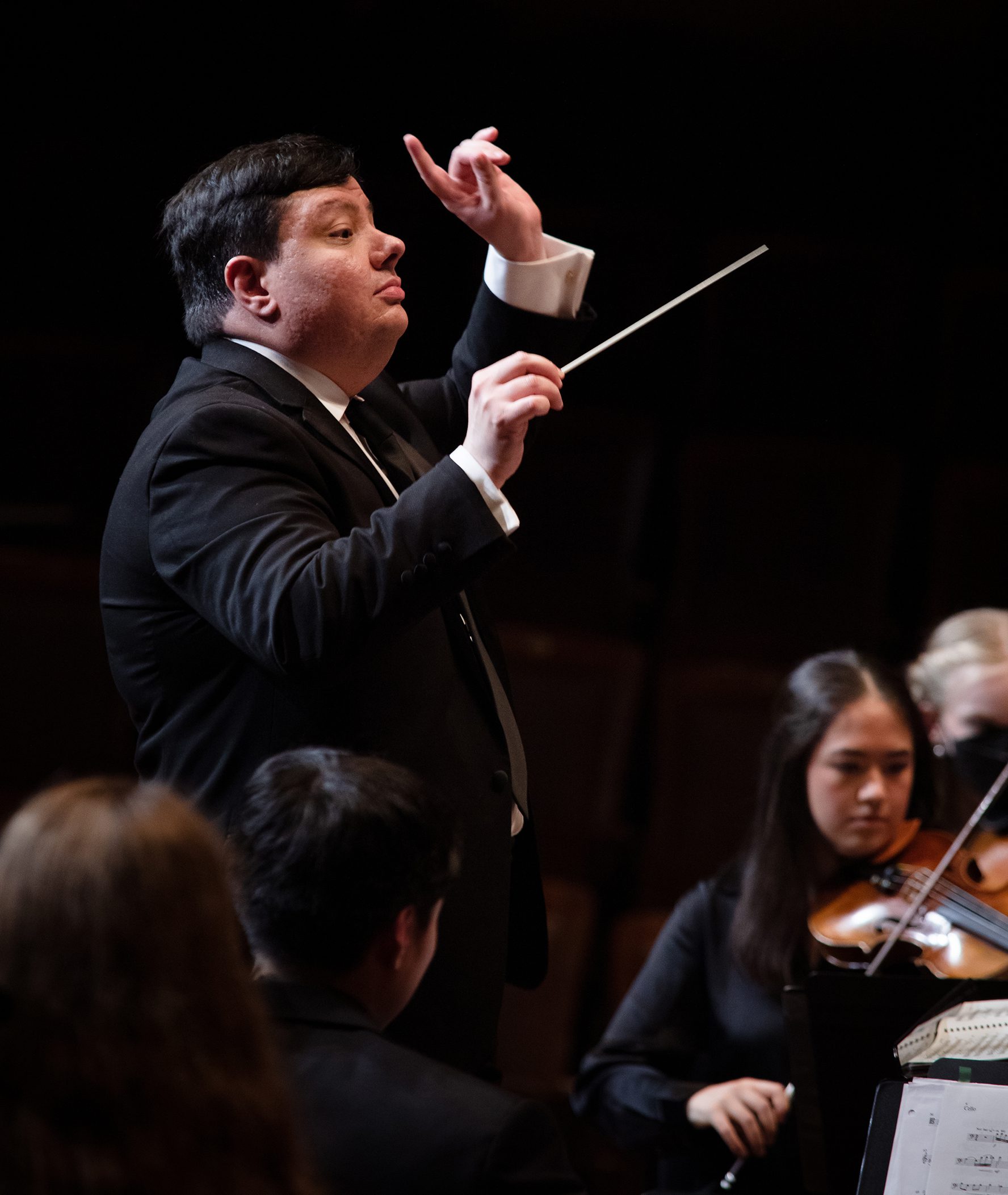 Juliano Aniceto conducting an orchestra.