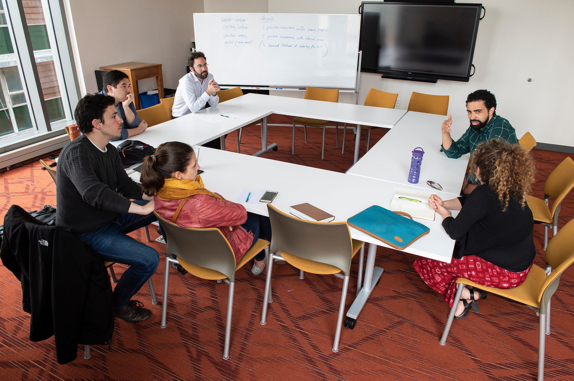 Students participating in a small workshop at a round table. Students participating in a small workshop at a round table.